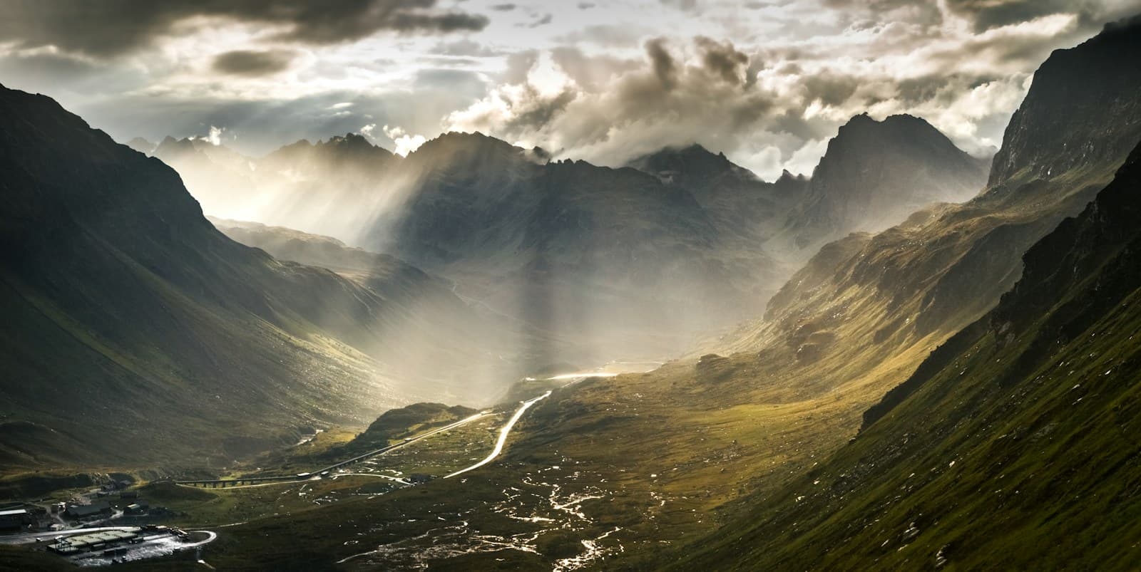 Light breaking through clouds above a mountain valley